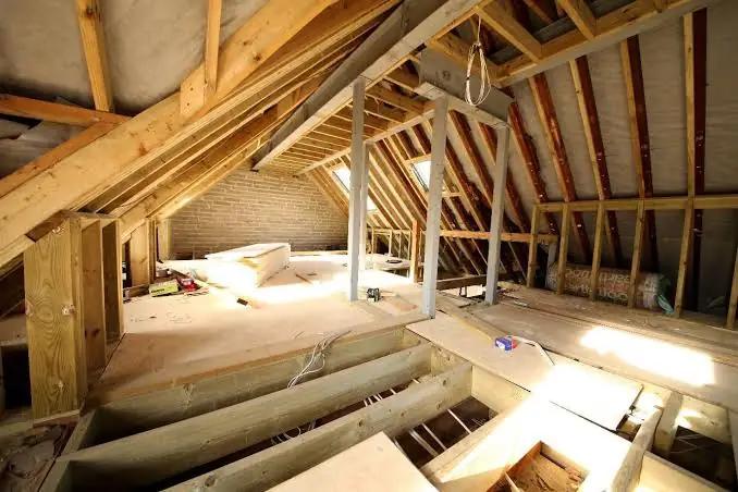 Exposed timber roof structure and floor joists inside a loft